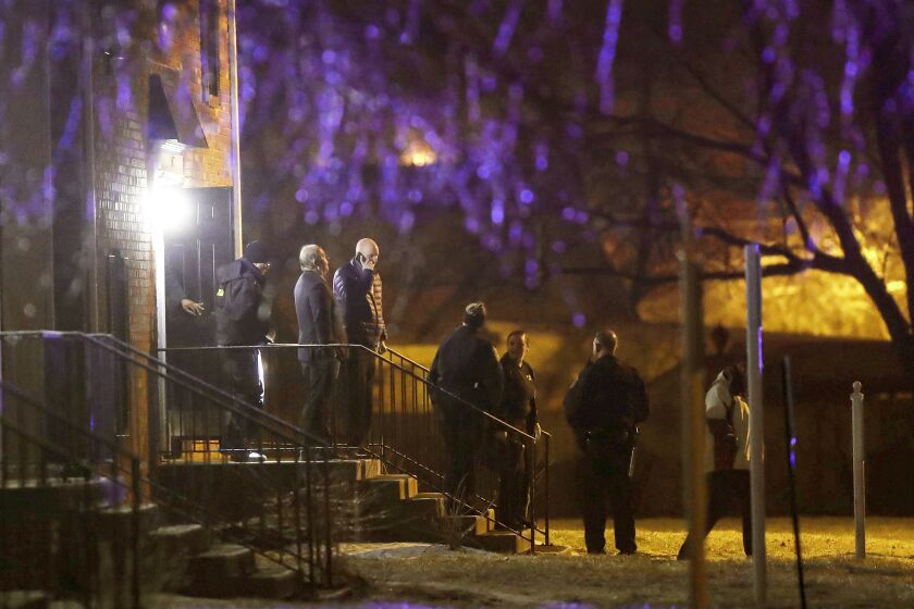 FILE - Officers walk out of the apartment complex where four people, one woman and three men, were found dead in Indianapolis, Feb. 5, 2020. Two men convicted of murder and other charges in the fatal Indianapolis shootings of three young men and a young woman were both sentenced Friday, March 31, 2023, to 220 years in prison. (Grace Hollars/The Indianapolis Star via AP, File)