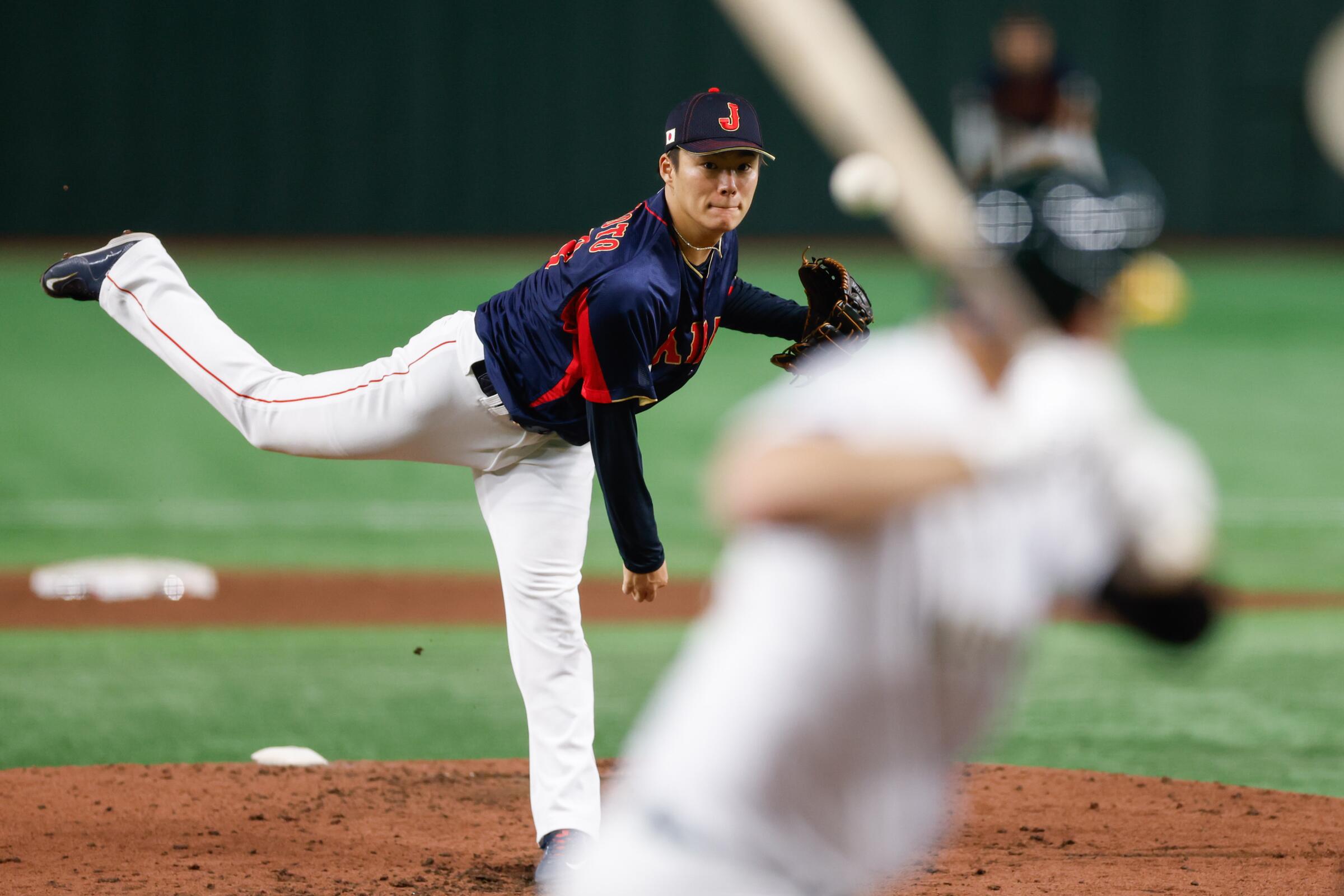 Yoshinobu Yamamoto of Team Japan pitches during a World Baseball Classic game against Australia.
