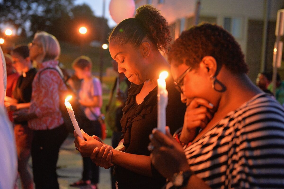 Mourners pause for prayer during a vigil for Jamyla Bolden on Thursday in Ferguson, Mo. Jamyla, 9, was hit and killed by a stray bullet as she was doing homework on her mother's bed.