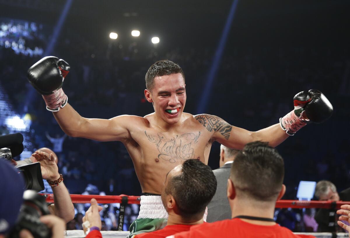 Oscar Valdez celebrates after defeating Evgeny Gradovich in the fourth round of their featherweight title bout Saturday in Las Vegas.