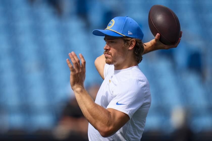  Chargers quarterback Justin Herbert warms up before a game against the Carolina Panthers.