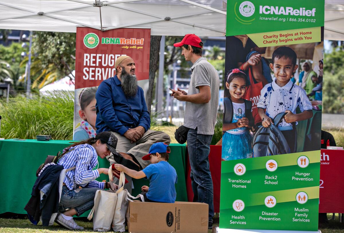 People gather at a booth at the World Refugee Day event 