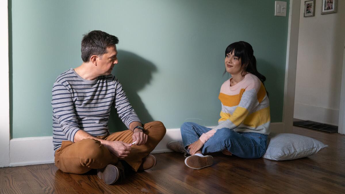 Two people sit on the floor