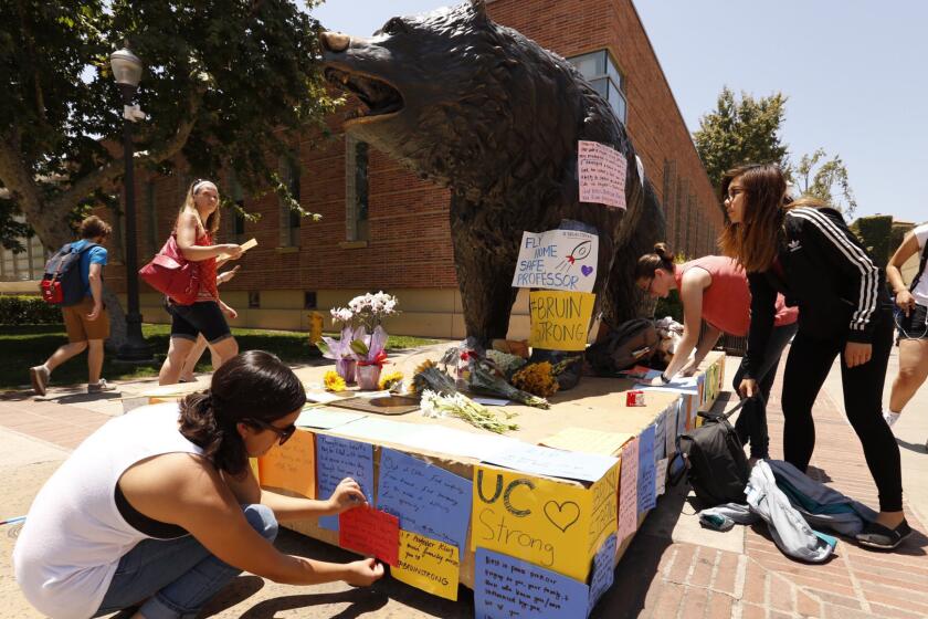 UCLA students write and post notes on the bear on UCLA's Bruin Walk on Thursday, a day after the deadly shooting on campus.