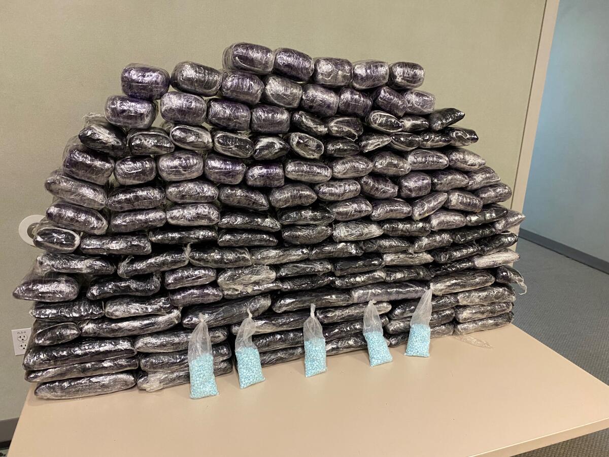 About 1 million fentanyl pills wrapped in plastic bundles are on a table