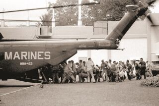 U.S. military and civilian personnel rush to board a Marine helicopter during the evacuation of the U.S. Embassy in Saigon, April 29, 1975.