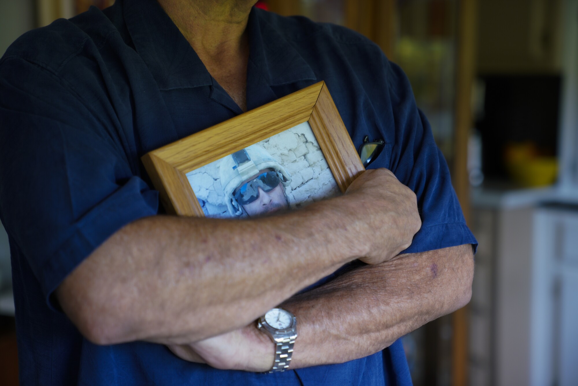 Kenny Necochea, Sr. holds a photo of his son, Kenny Necochea, Jr.