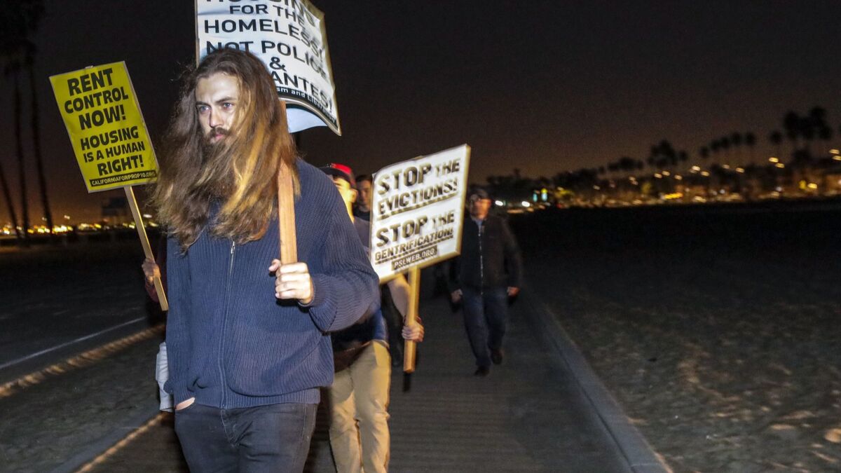 Protesters march on the beach in Belmont Shore to oppose the predawn homeless patrol.
