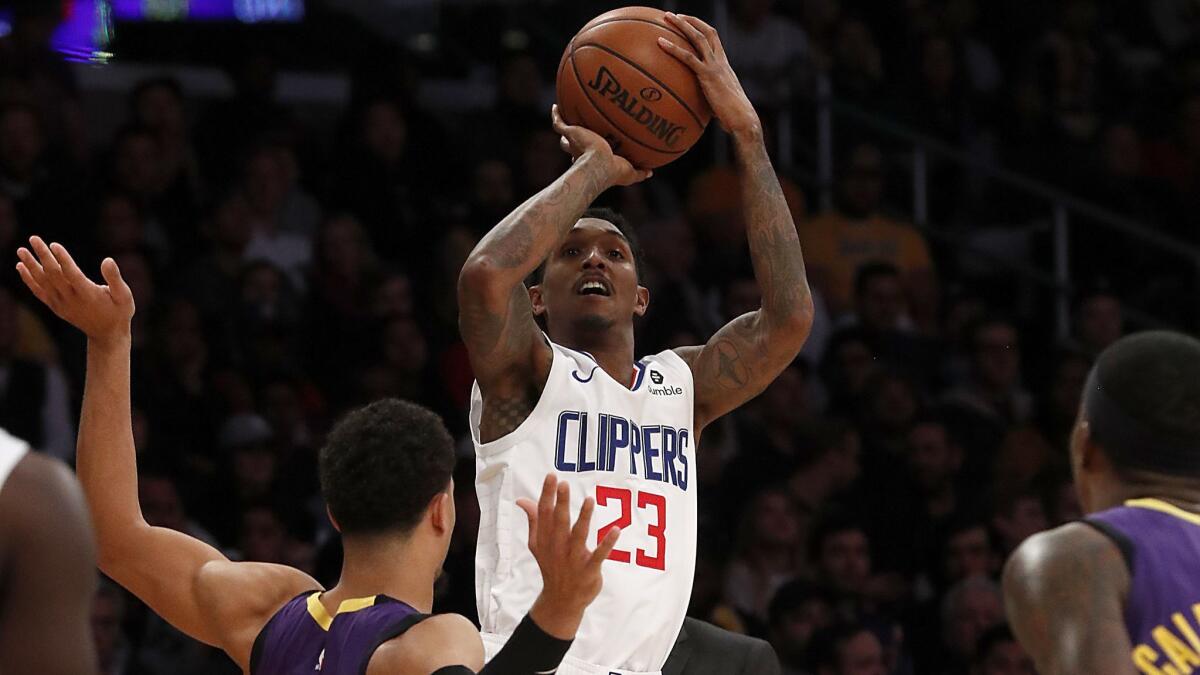 Clippers guard Lou Williams shoots over Lakers guard Josh Hart, left, and Kentavious Caldwell-Pope in the fourth quarter on Dec. 28, 2018, at Staples Center.