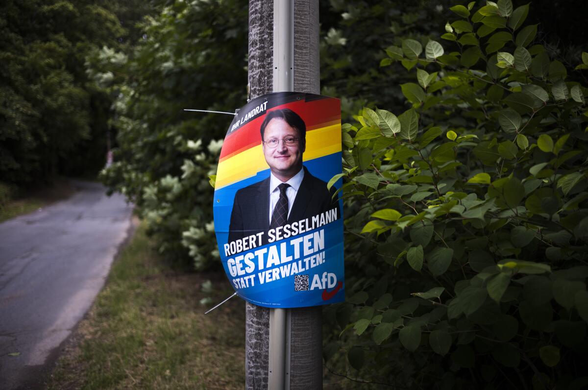 Election campaign poster of far-right AfD candidate Robert Sesselmann on a street pole.