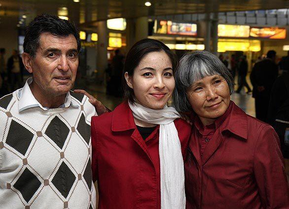 Roxana Saberi, center, surrounded by her mother, Akiko, and her father, Reza, arrives at the airport in Austria.