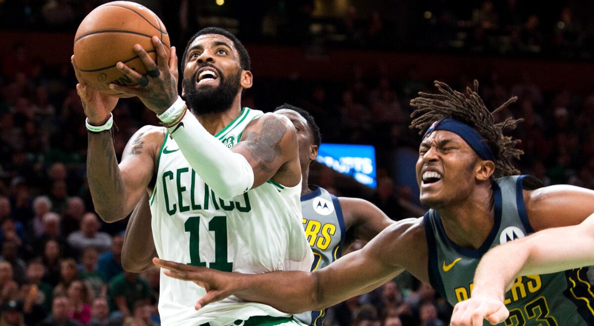 Celtics guard Kyrie Irving drives for a layup against Pacers center Myles Turner on Friday night.