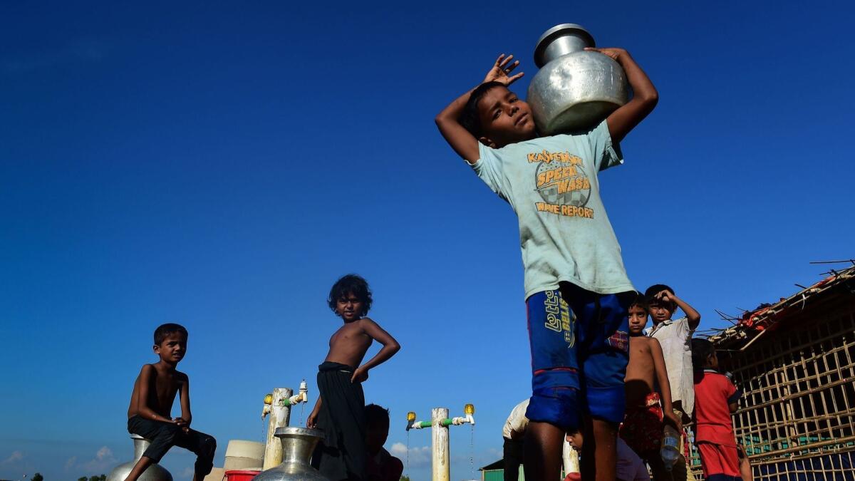 Rohingya refugee children collect drinking water from a tube well at Hakimpara refugee camp in southern Bangladesh.