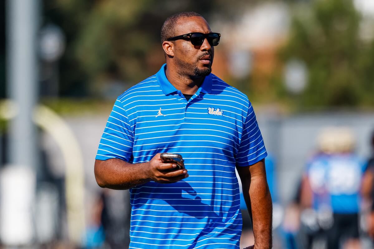 Butler Benton, general manager of recruiting and personnel for UCLA football, walks on the field.