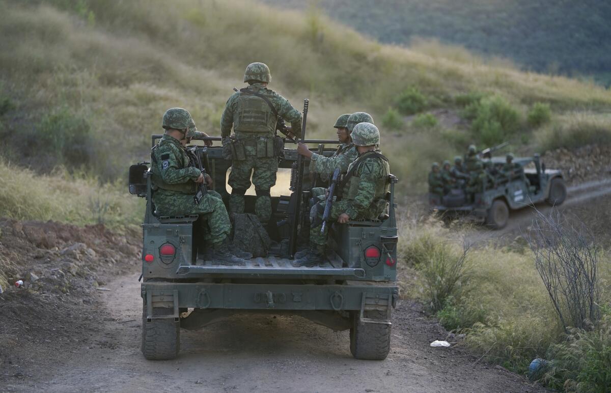 ARCHIVO - Soldados patrullan cerca de la aldea Plaza Vieja en el estado de Michoacán