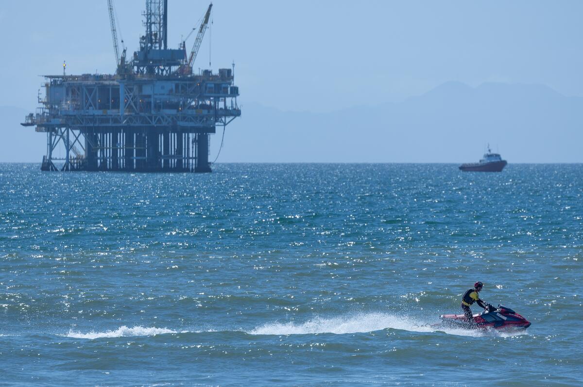 A Huntington Beach Lifeguard patrols the water near Huntington Dog Beach on Friday.