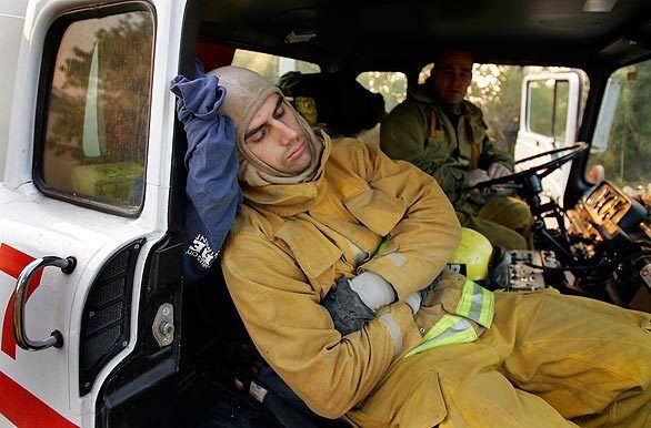 Los Angeles firefighter Mike Catalano closes his eyes after 48 hours of fighting the Marek and Sesnon fires.