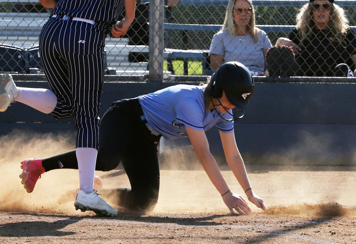 Corona del Mar's Alex Boserup slides safe at home against Newport Harbor in the Battle of the Bay game.
