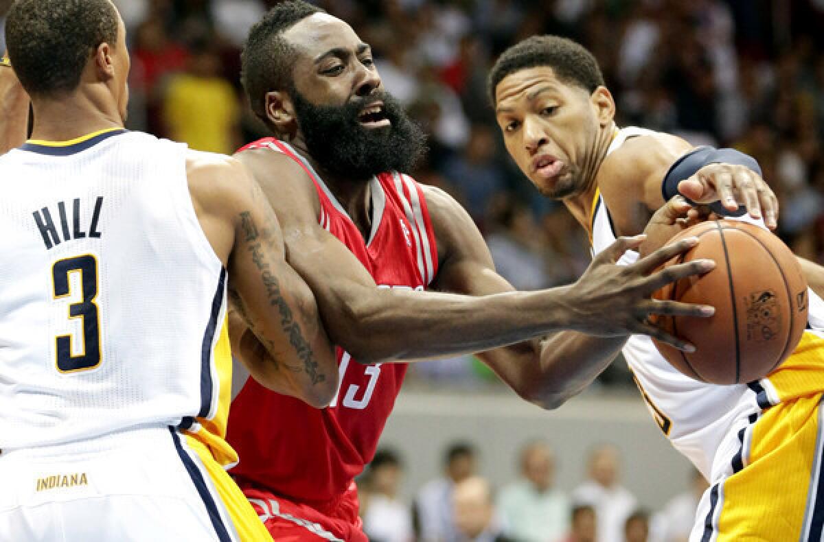 Rockets guard James Harden tries to split the defense of Pacers guard George Hill and forward Danny Granger during a NBA preseason game.