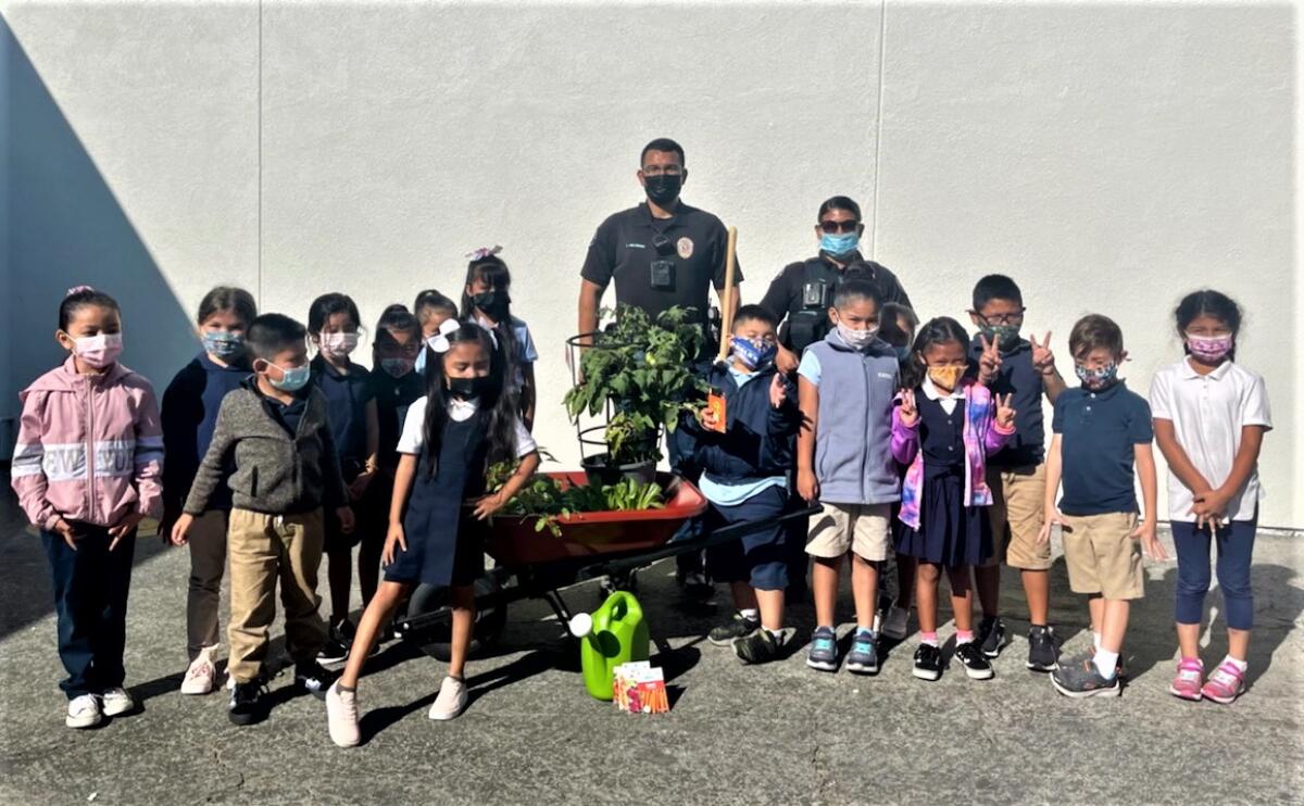 CMPD school resource officers Anthony Melendez, center, and Eloisa Peralta with Rea Elementary School students.