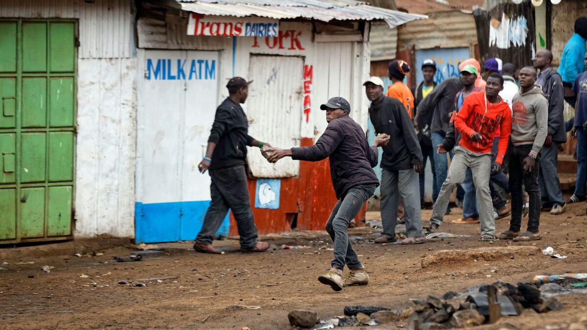 Protesters throw rocks at riot police during clashes in the Kawangware slum of Nairobi, Kenya. International observers on Thursday urged Kenyans to be patient as they awaited final election results.
