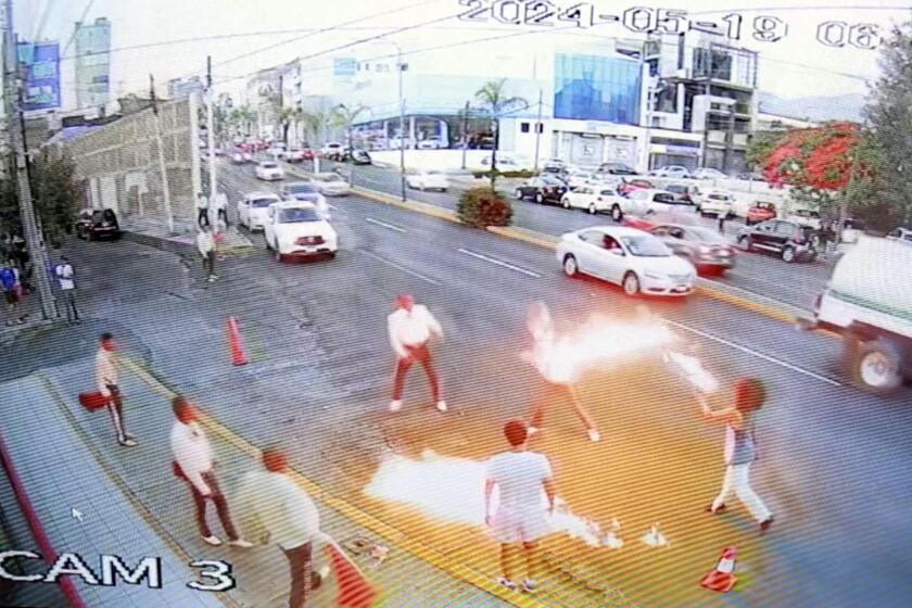 En esta imagen tomada de un video proporcionado por Jorge Toscano, un tragafuego (en la derecha) se enfrenta a unos mariachis con guitarras, el domingo 19 de mayo de 2024, en Morelia, México. (Jorge Toscano via AP)