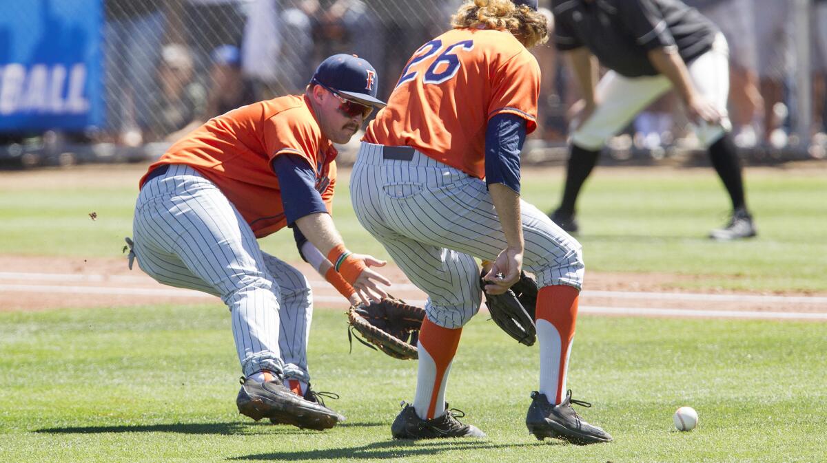 Cal State Fullerton's Dillion Persinger, left, tracks down a bunt before throwing a Long Beach State runner out at first base in the first inning during game one of a best-of-three series NCAA Super Regional at Blair Field in Long Beach on June 9.