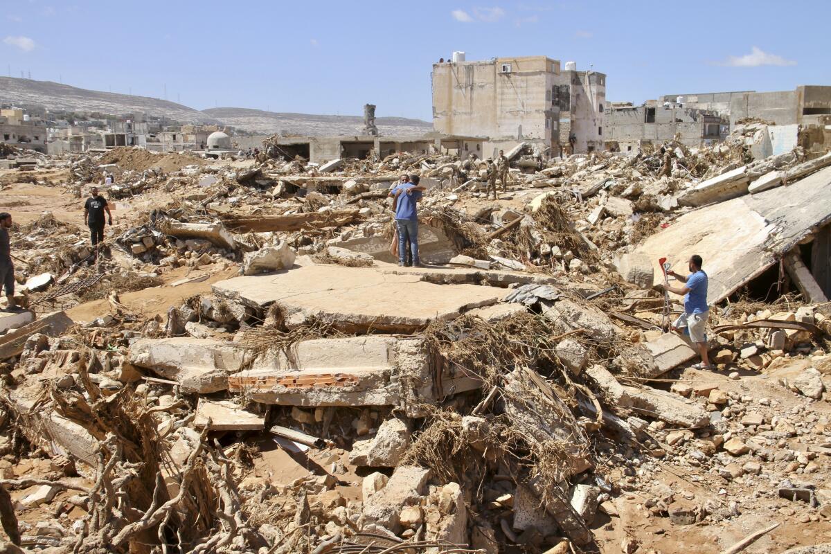 People stand amid rubble in Libya.