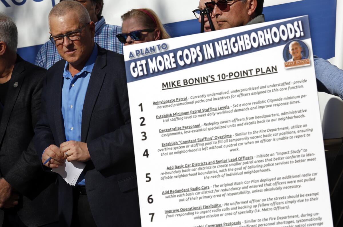 L.A. Councilman Mike Bonin stands next to a poster that illustrates his 10-point plan at a news conference outside the LAPD Ahmanson Recruit Training Center in Los Angeles.