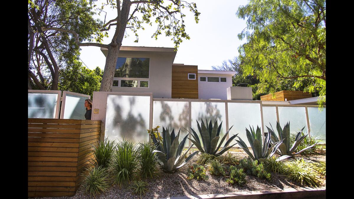 From the street, the house has a modern sensibility with a surplus of glass, vertical lines and cedar siding. The opaque fence creates a nice backdrop for the front courtyard.