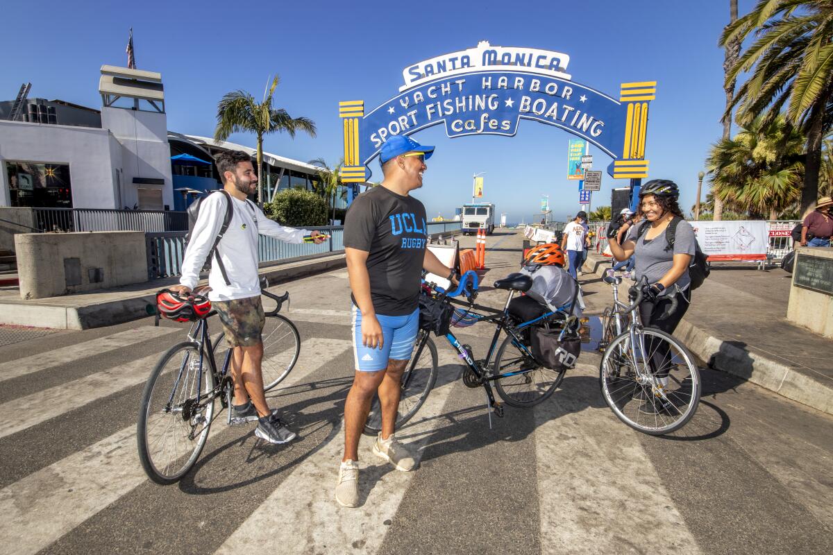 Fellow riders Bryan Villalpando and Noemi Garcia mark the end of their bicycle ride with Juan Pablo Garces Ramirez 