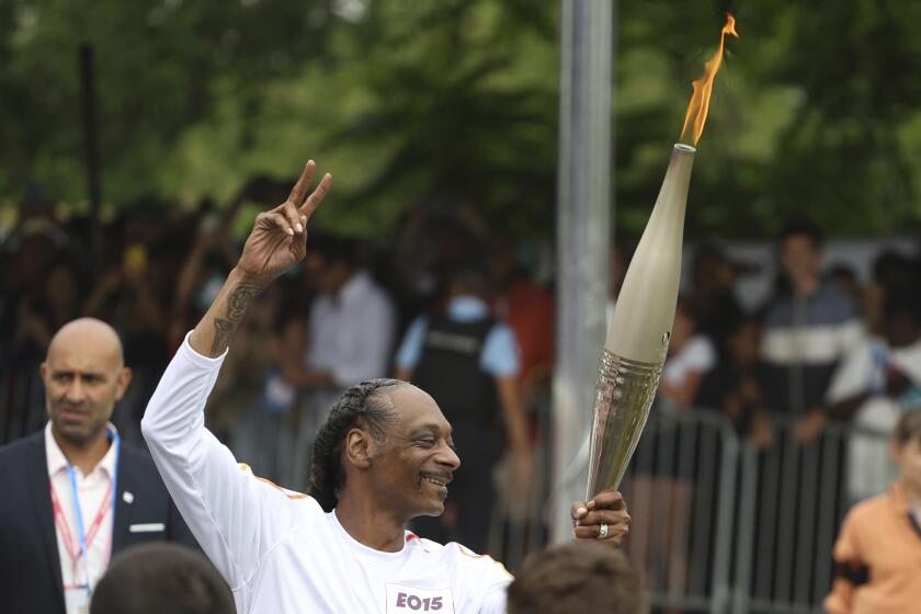 Snoop Dogg porta la antorcha olímpica en los Juegos Olímpicos de Verano de 2024, el viernes 26 de julio de 2024, en Saint-Denis, en las afueras de París, Francia. (Foto AP/Aurelien Morissard)