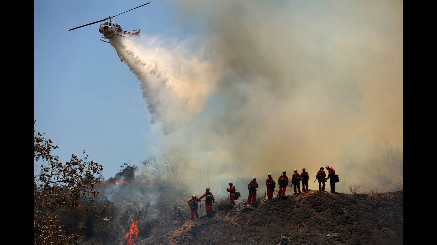 A helicopter joins in the fight against a wildfire that broke out in Duarte.