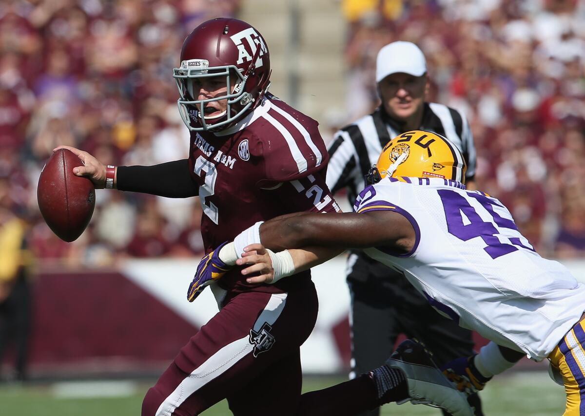 Texas A&M; quarterback Johnny Manziel tries to evade LSU linebacker Deion Jones on Saturday.