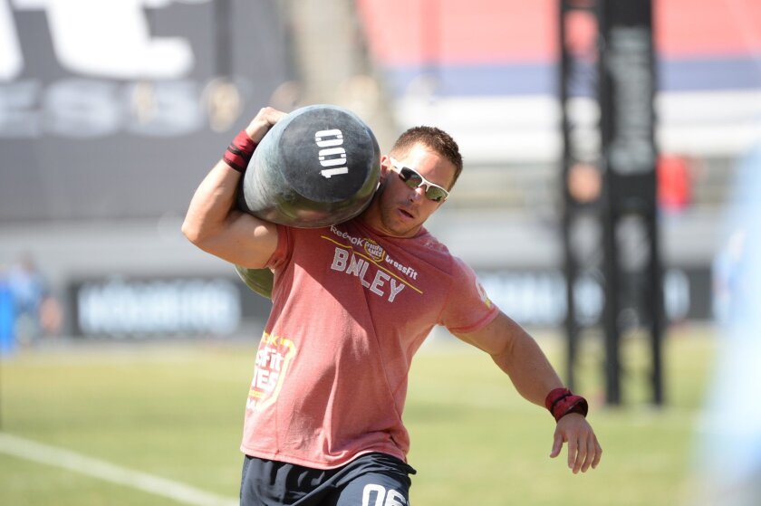San Diegan Dan Bailey carries a 100-pound bag in a race during a CrossFit competition.