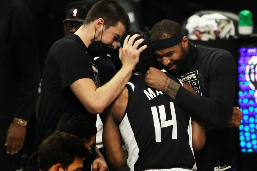 LOS ANGELES, CA - JUNE 18, 2021: Teammates hug high-scorer LA Clippers guard Terance Mann (14) during a timeout as the Clippers beat the Utah Jazz to advance to the Western Conference NBA Playoffs at Staples Center on June 18, 2021 in Los Angeles, California.(Gina Ferazzi / Los Angeles Times)