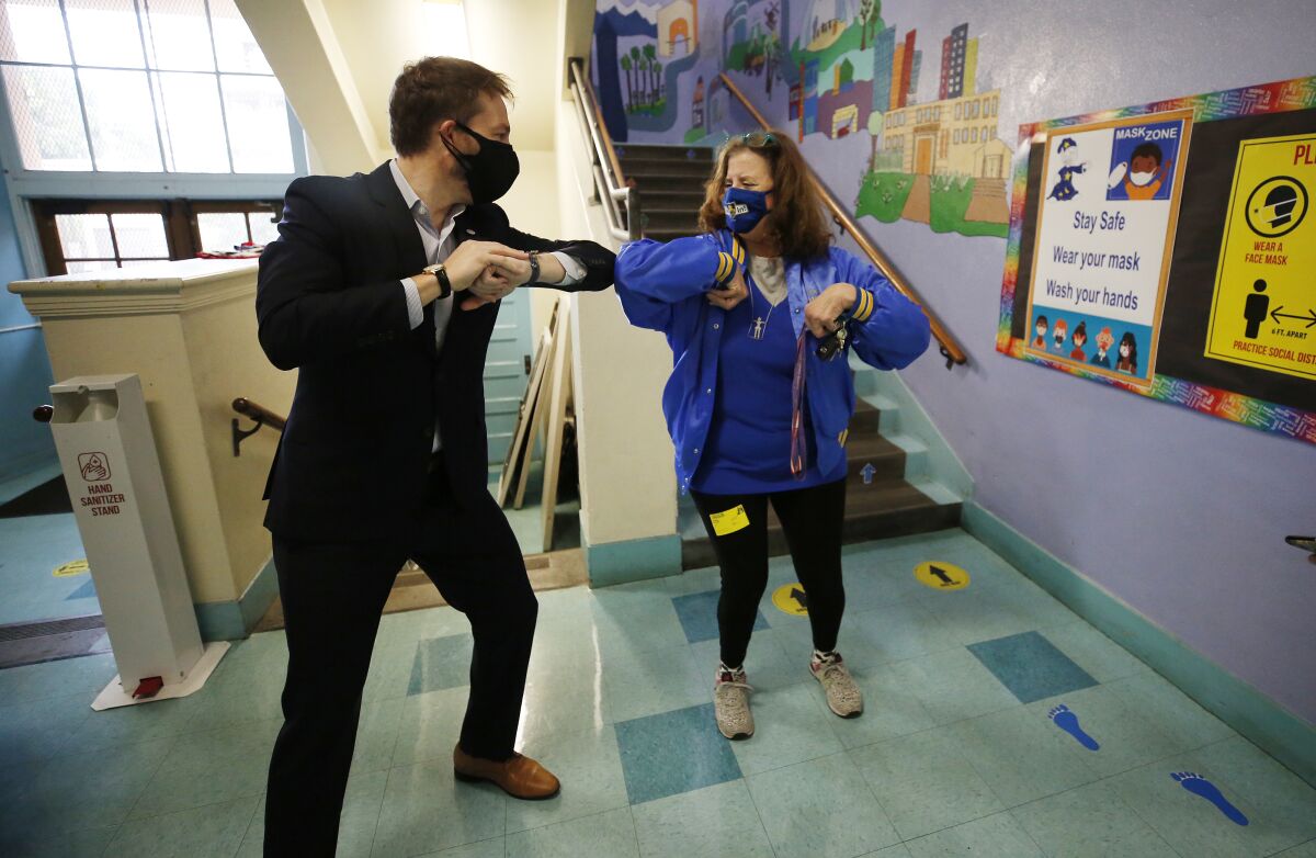 L.A. school board member Nick Melvoin bumps elbows with a school staffer.