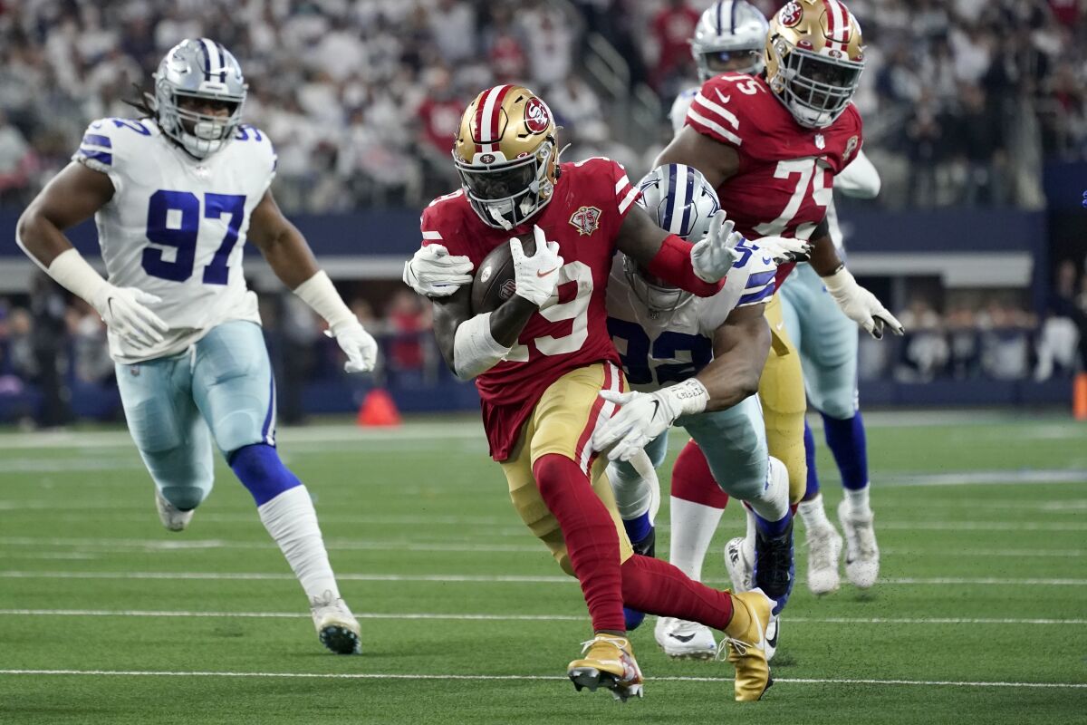 San Francisco wide receiver Deebo Samuel (19) tries to break away from Dallas Cowboys defensive end Dorance Armstrong.