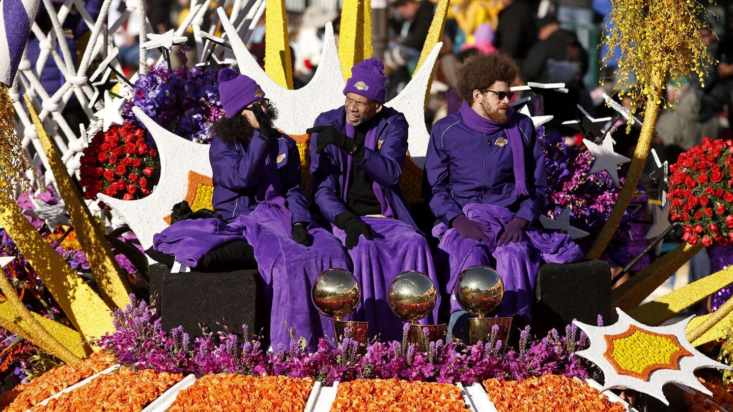 Kareem Abdul Jabbar waves from the Los Angeles Lakers "Every Second is an Adventure" float.