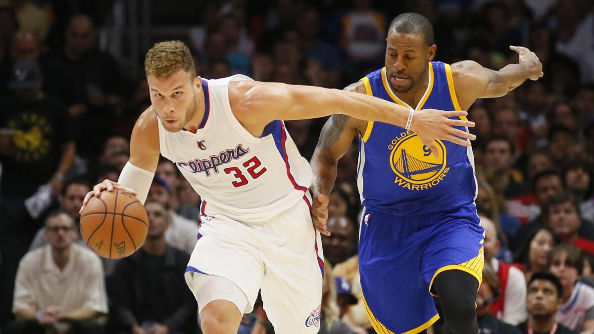 Clippers forward Blake Griffin, left, drives to the basket ahead of Golden State Warriors forward Andre Iguodala during the Clippers' 110-106 loss at Staples Center on Tuesday.