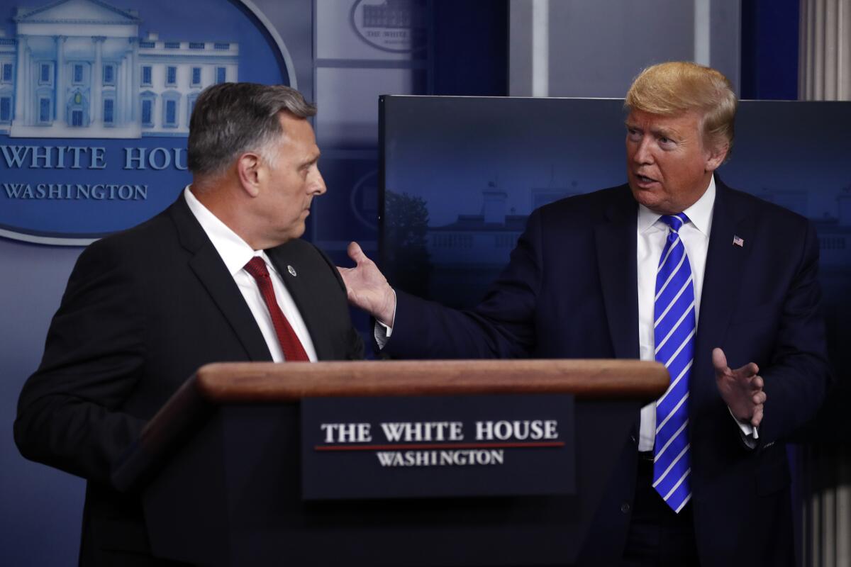 President Trump talks with William Bryan, head of science and technology at the Department of Homeland Security, as he speaks about the coronavirus Thursday in Washington.
