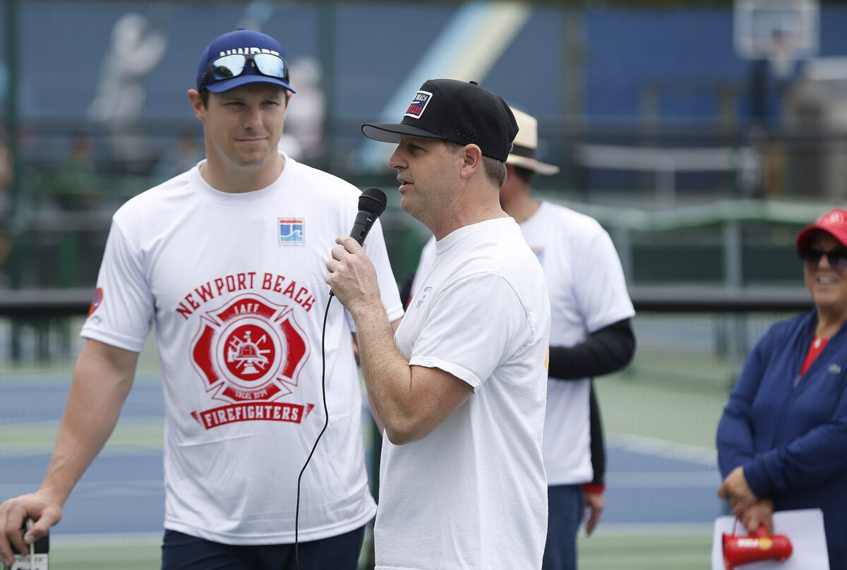 Fire Chief Jeff Boyles, right, welcomes players with fellow firefighter and organizer Jim O'Neil.