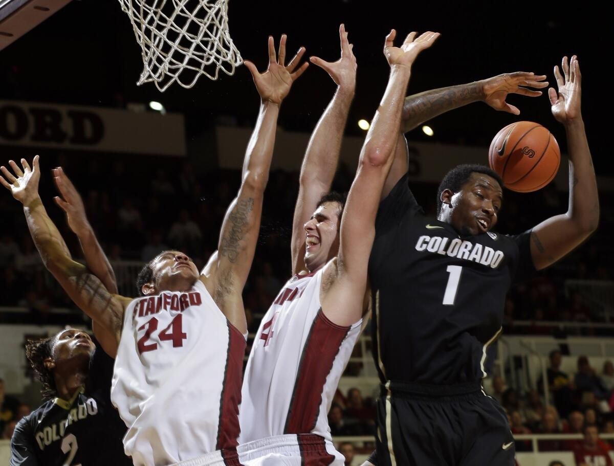 Colorado's Wesley Gordon, right, reaches for a rebound near teammate Xavier Johnson (2) and Stanford's Josh Huestis (24) and Stefan Nastic (4).