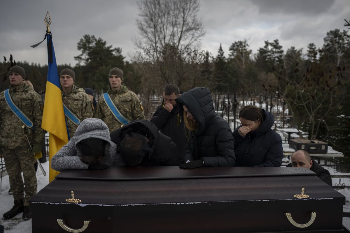 Relatives grieving by the coffin of a fallen Ukrainian serviceman