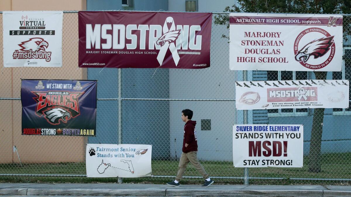 Signs outside Marjory Stoneman Douglas High School in Parkland, Fla., on Feb. 14 mark the first anniversary of the shooting that killed 17.