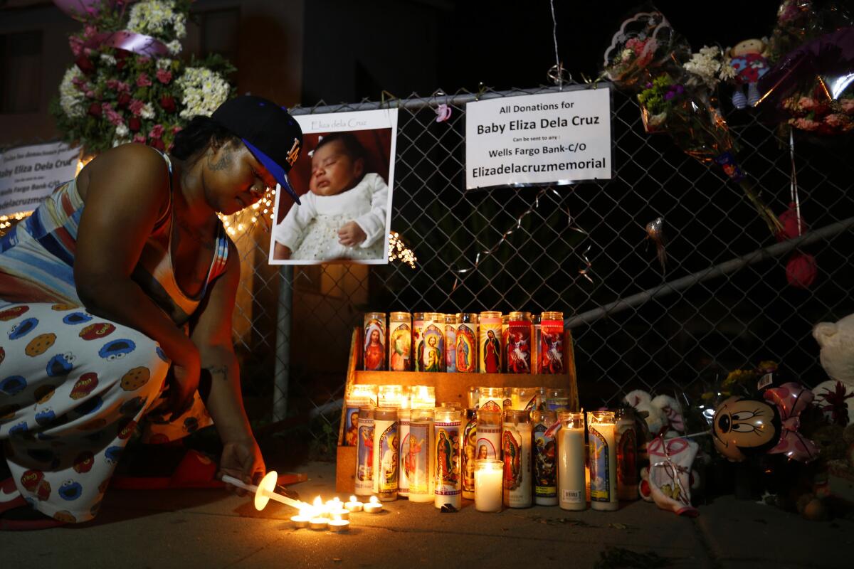 Patches Pelts of Long Beach lights a candle at a vigil to mourn the death of 3-week-old Eliza Delacruz on Jan. 9.