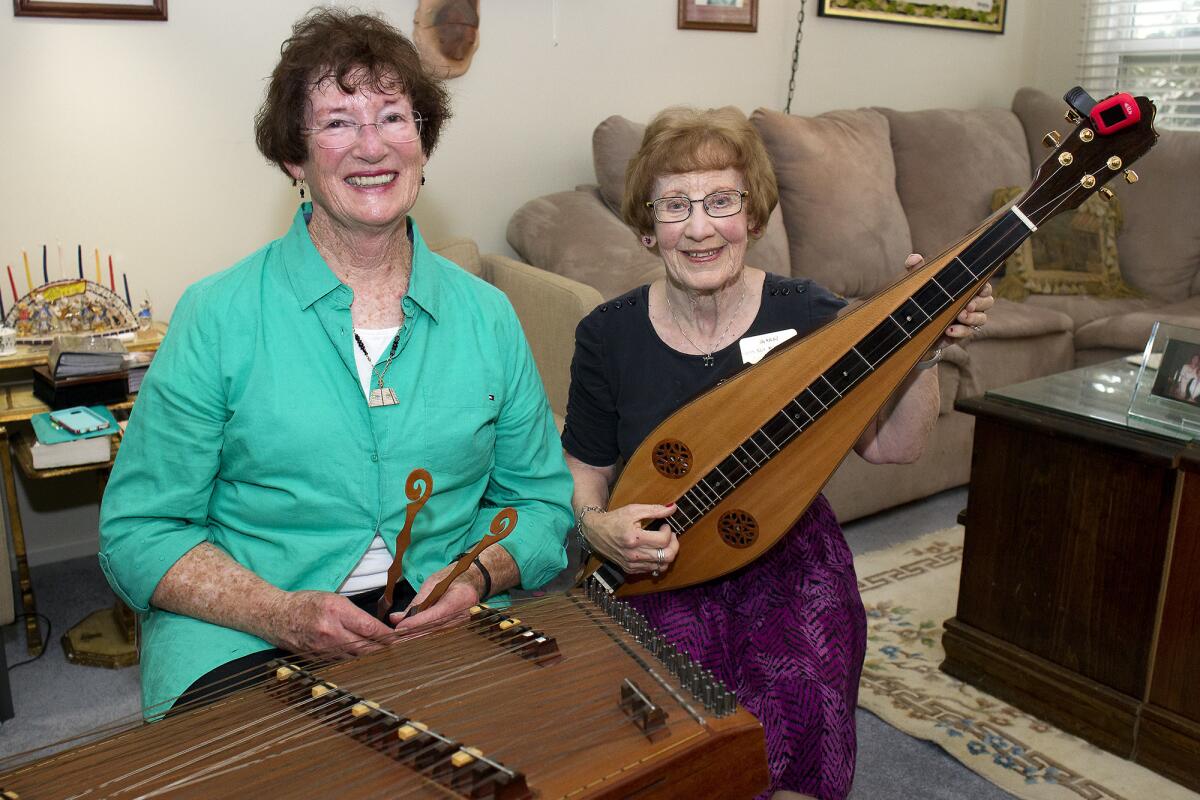 Barbara Gershman, left, and Roberta "Bobbi" Adler display their dulcimers at Adler's home in Garden Grove. Gershman has a hammer dulcimer and Adler holds a fretted dulcimer.