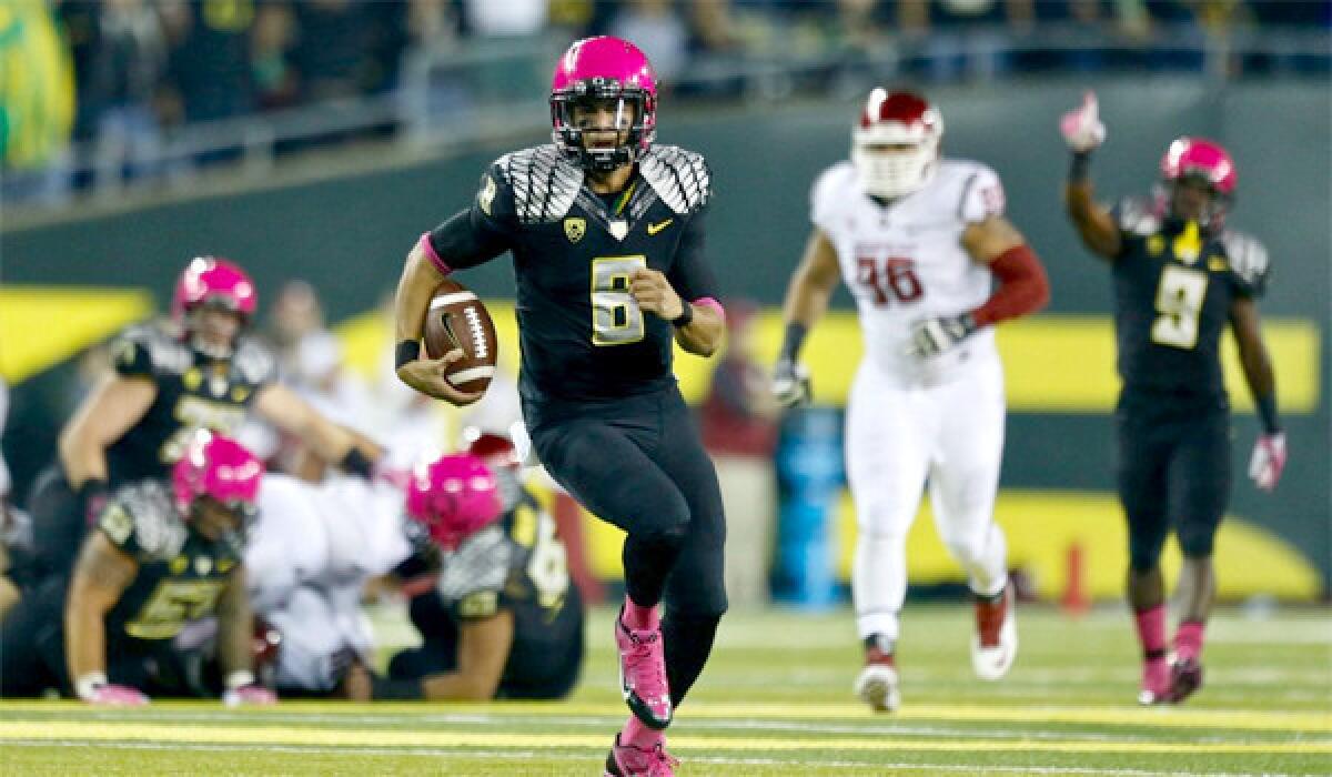 Oregon quarterback Marcus Mariota scores on the Ducks' opening drive against Washington State on Oct. 19. Mariota has passed for 19 touchdowns while rushing for another nine this season.