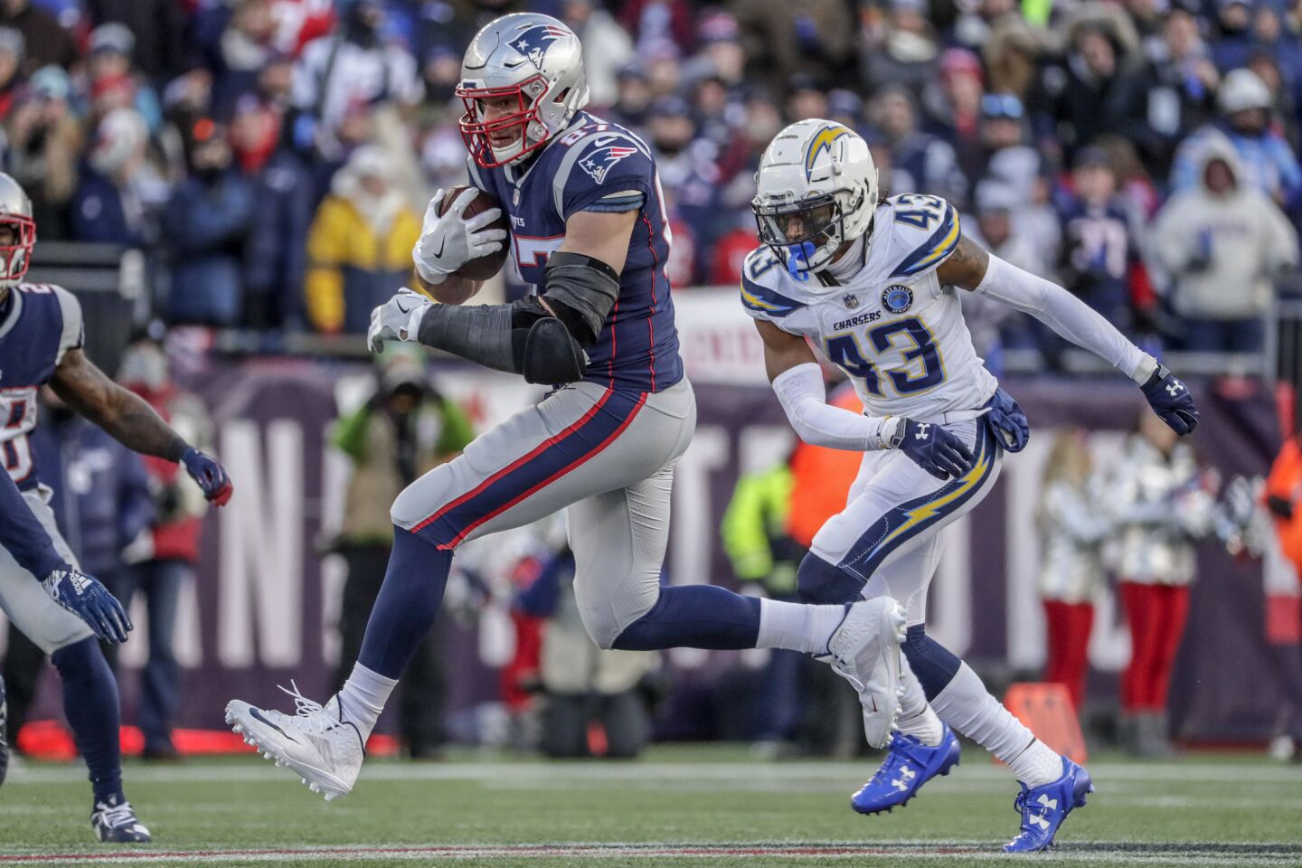 New England Patriots tight end Rob Gronkowski sprints past Chargers cornerback Michael Davis for a 25-yard gain in the third quarter in the NFL AFC Divisional Playoff at Gillette Stadium.