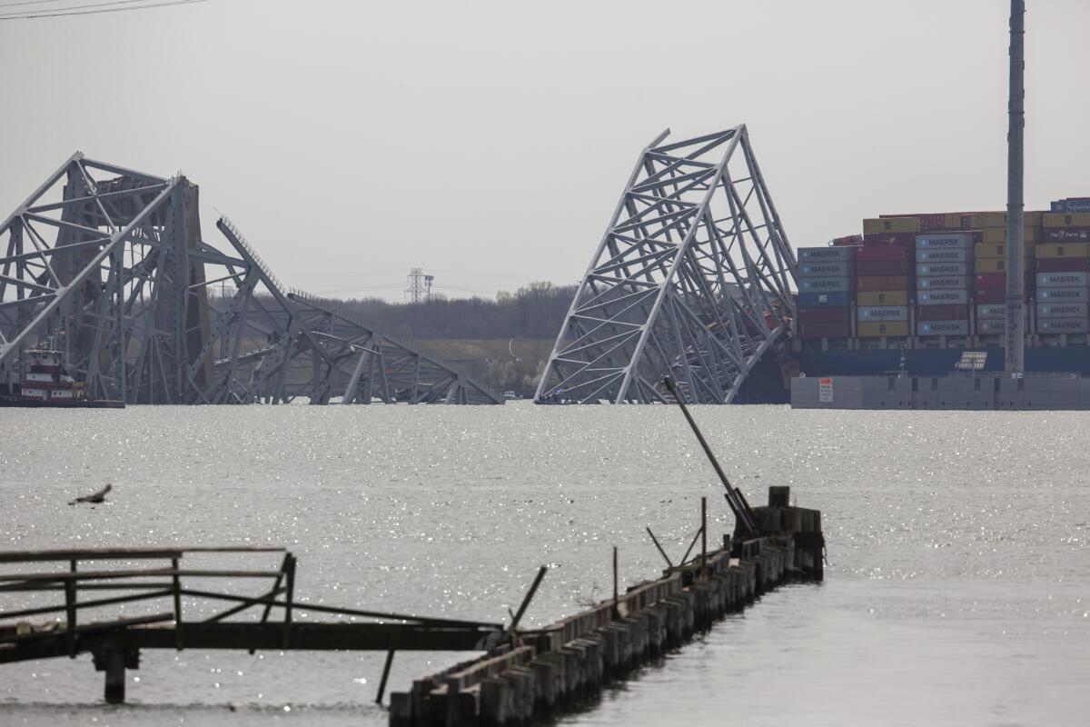 Collapsed bridge next to cargo ship in harbor